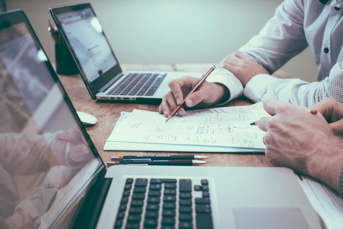 Reviewing financial reports beside a laptop