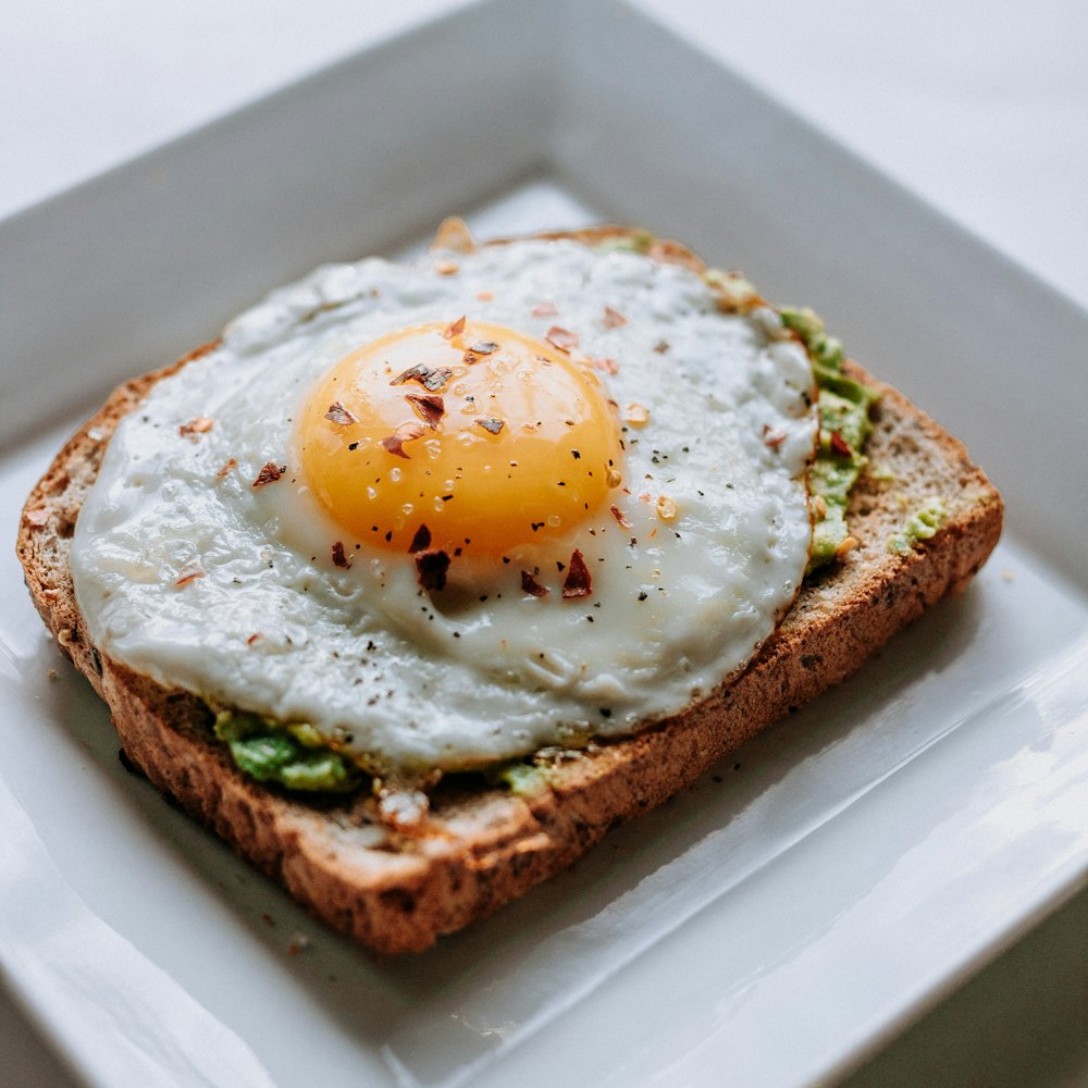 Fried egg on toasted sourdough served on a white plate for brunch